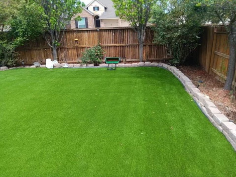 Backyard with artificial turf and stone edging